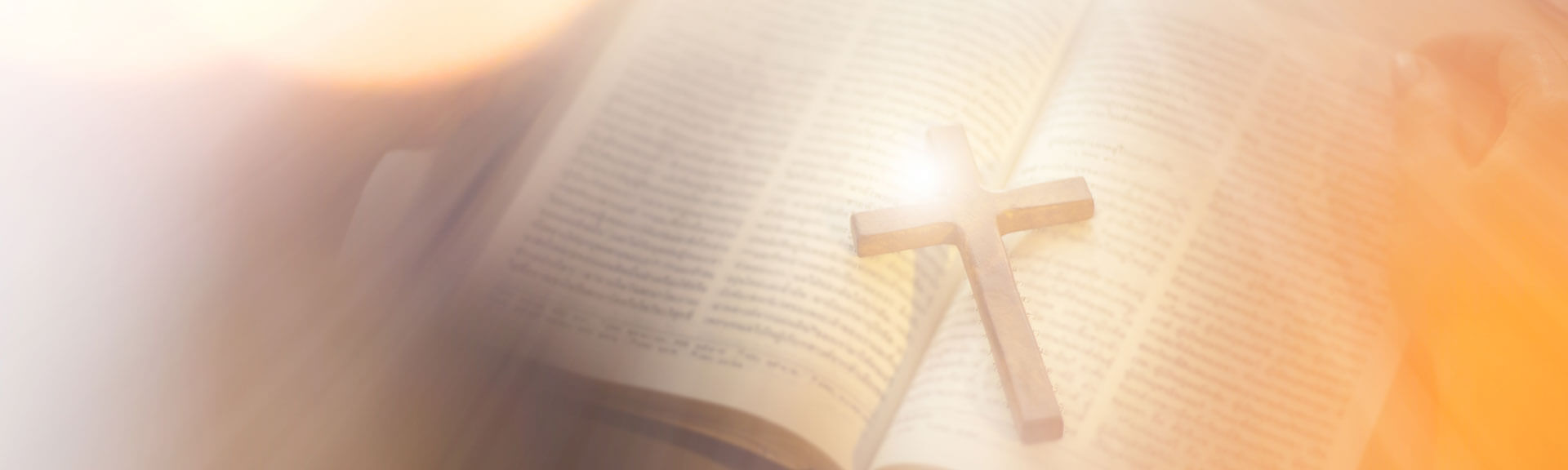 Asian Woman Praying And Holding A Cross With Her Bible On Table.